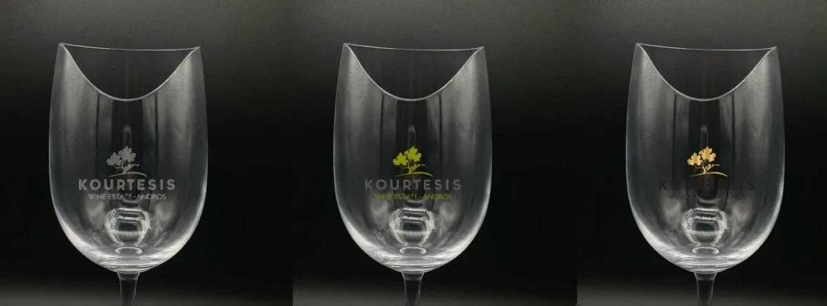 Three Les Aromes glasses etched with a winery logo in silver, green and gold
